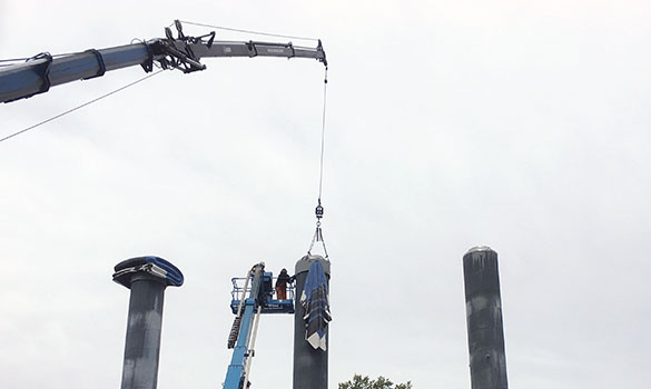 Crane lifting art onto building roof