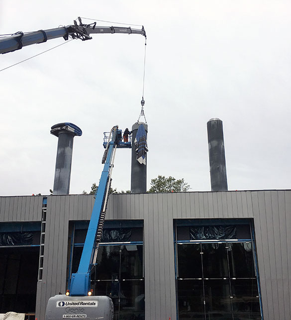 Crane lifting art onto building roof